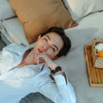 a man laying on a bed next to a basket of fruit