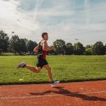 A man running across a field on a sunny day