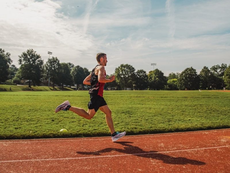 A man running across a field on a sunny day