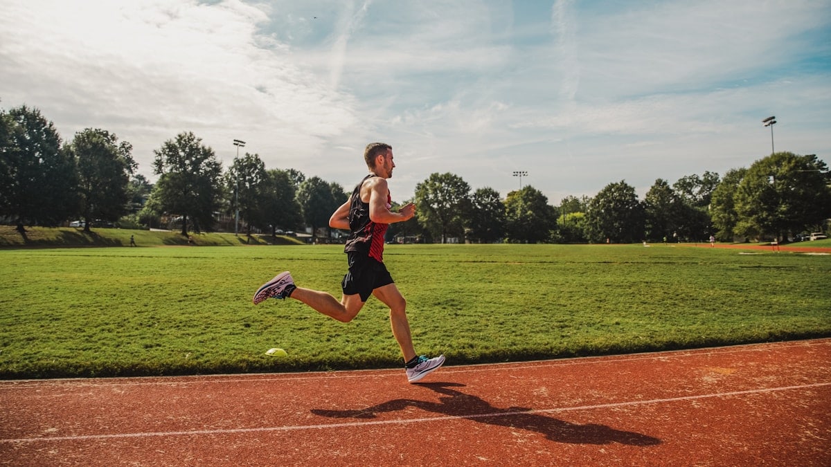 A man running across a field on a sunny day